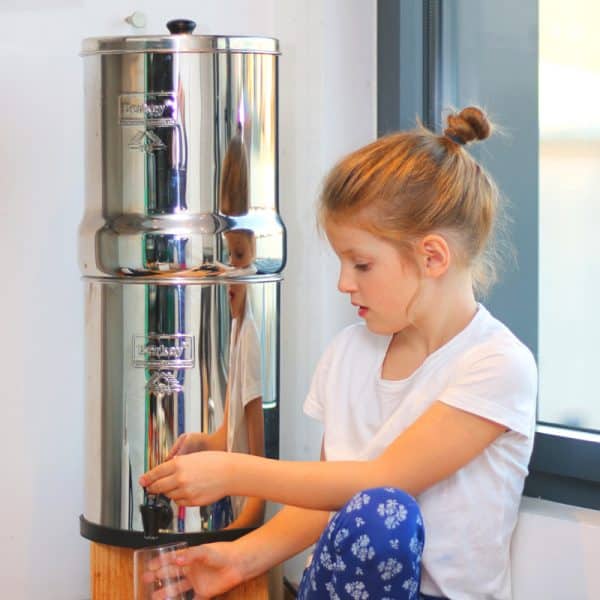 petite fille qui se sert un verre d'eau d'un filtre à eau